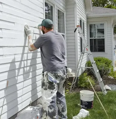 Amore Painters crew member painting the wall of a home