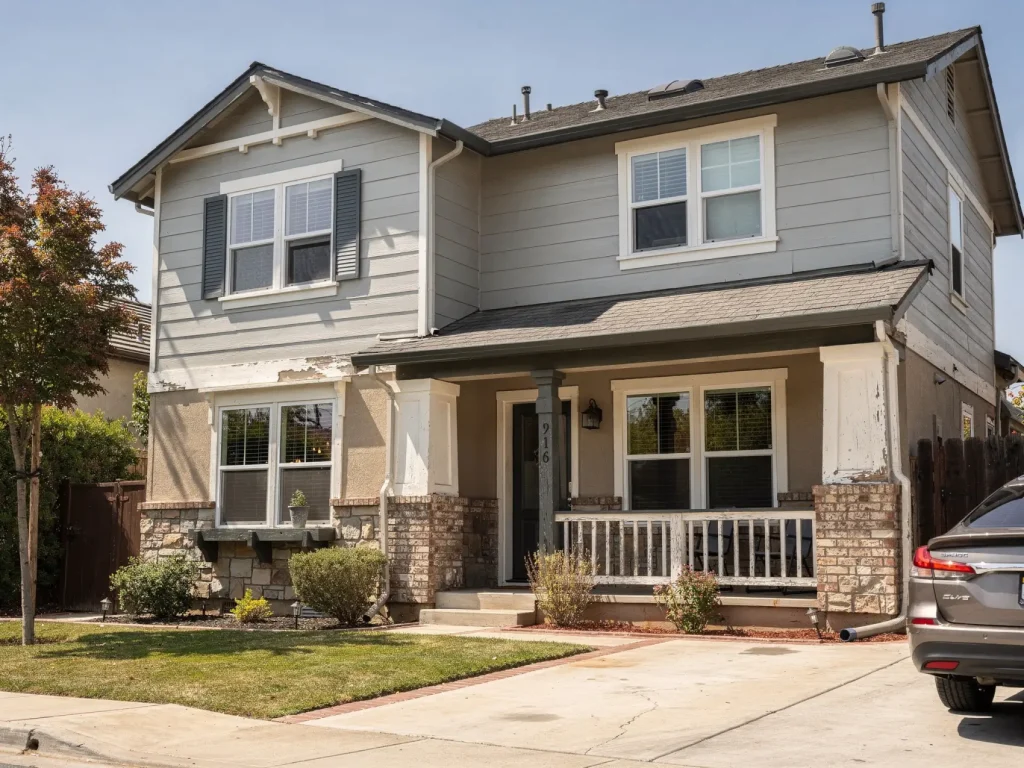 Two-story Pleasanton home with visible wear and peeling paint, showing how condition and size affect house painting costs