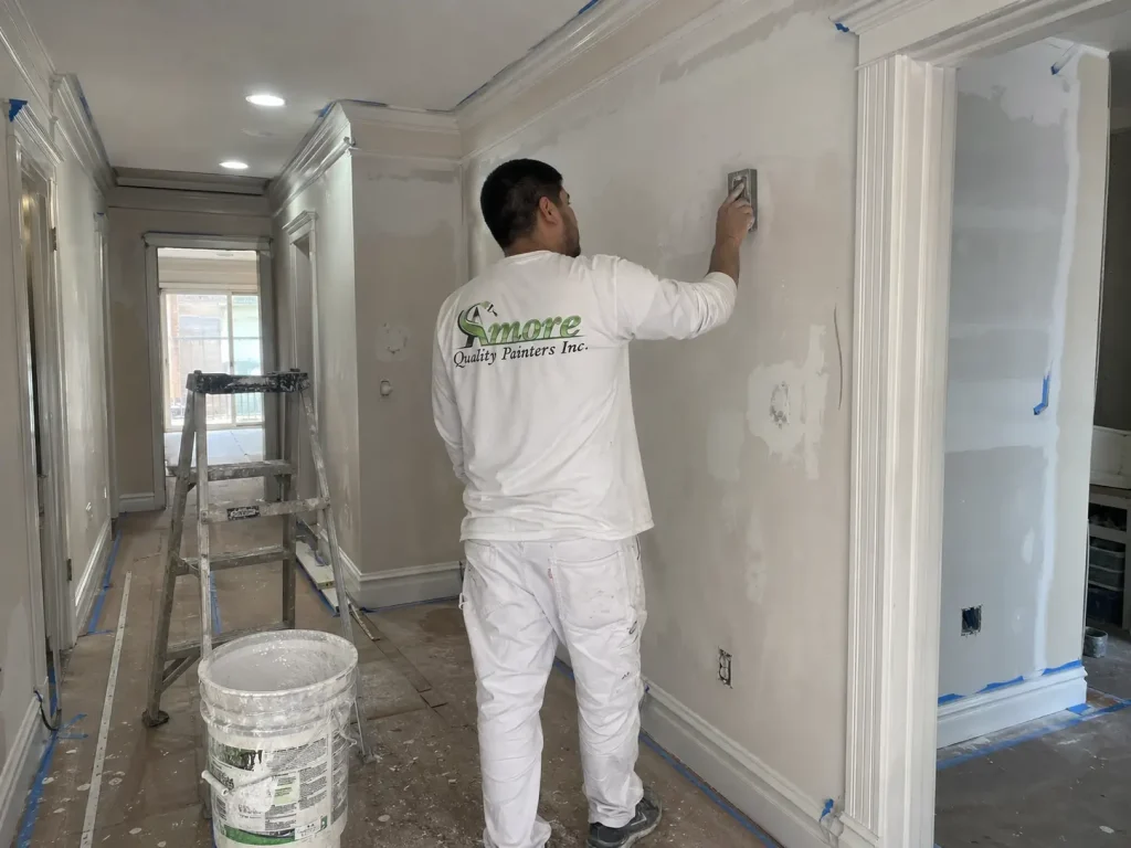 Amore Painters professional reviewing wall prep, trim details, and repair needs during an interior painting estimate walkthrough.