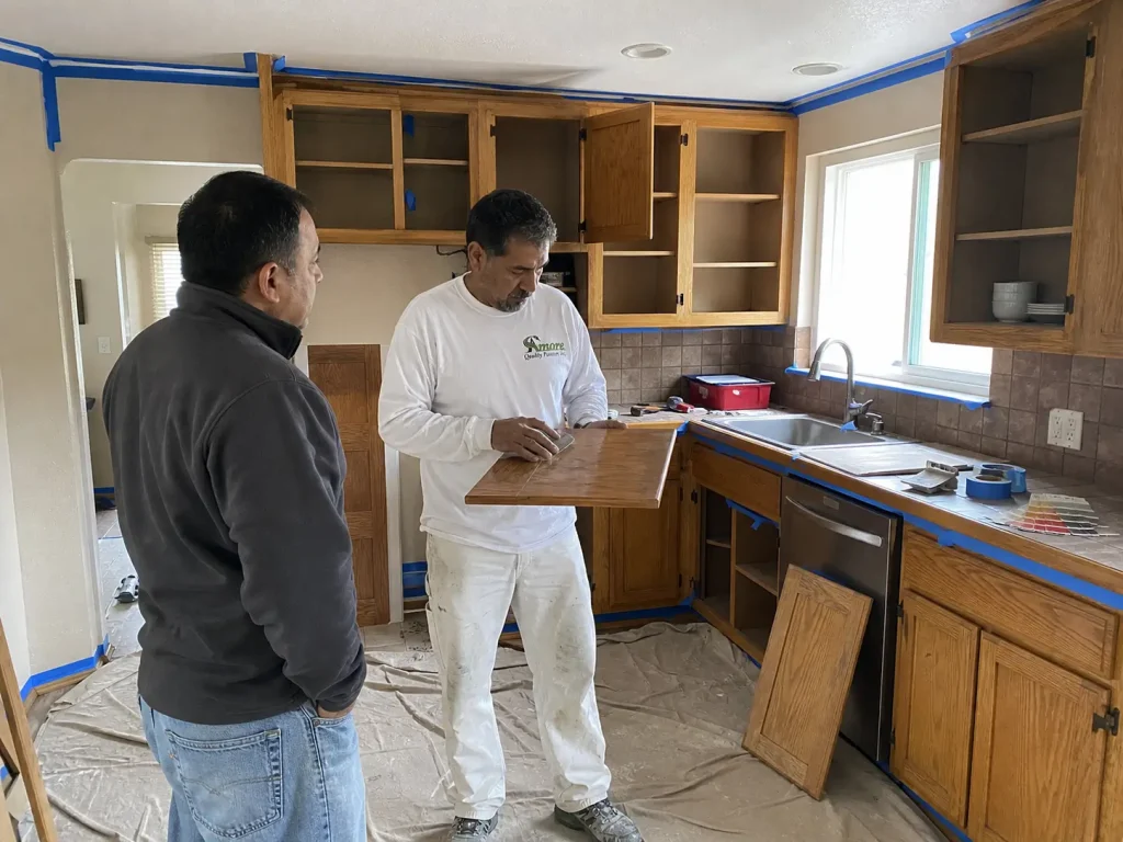 Amore Painters inspecting dated kitchen cabinets for repainting before a home sale